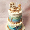 Adorning this ombre beach cake are delicate gold seahorses and shells nestled in sugary sand at the pinnacle and base of both tiers, evoking the treasures of a sunken pirate chest. 