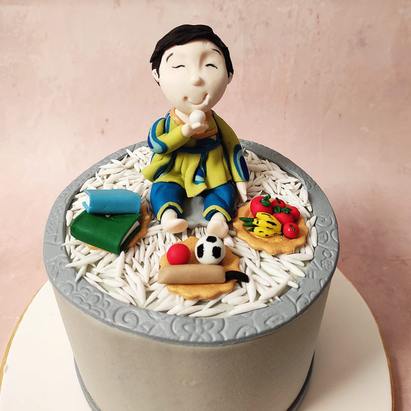 Encircling this central figure on this Annaprashan theme cake is an array of symbolic elements: fruits representing the sweet abundance of nature’s bounty; books denoting the quest for knowledge and wisdom; and sporty items symbolising the playful adventures that lie ahead. 