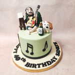 Atop the sugary stage of this Art Cake sits a captivating scene: a bearded musician, guitar in hand, strumming tunes in his living room adorned with pine trees.   Beside him, an edible figurine of his furry companion, a dog with a bow in its ear and a playful expression, adds a touch of canine whimsy to the design of this Guitarist Cake!