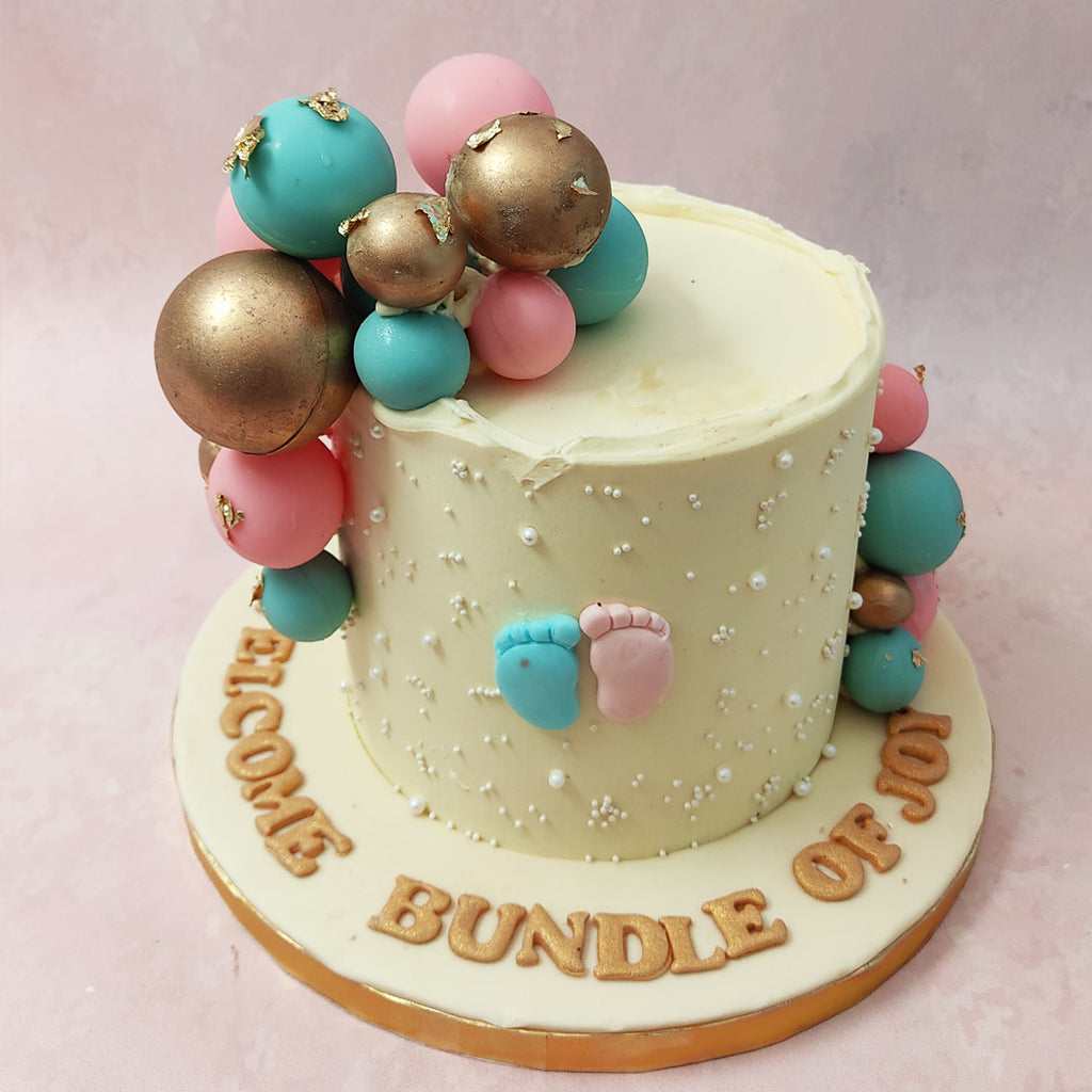 This he or she cake features a creamy base with one pink and one blue 3D foot at the centre. 