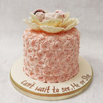 The perfect design for a mom to be cake or a baby shower cake, the base of this piece is covered in elegant, light pink swirls of decadent buttercream that resembles pink roses.