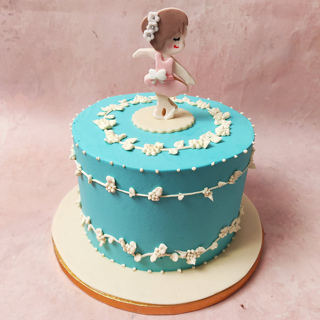 Adorned with delicate white flowers in her hair, elegantly tied in a bun, she epitomises the beauty and poise of dance, representing the dancer for whom this Ballerina Birthday Cake For Girls is designed