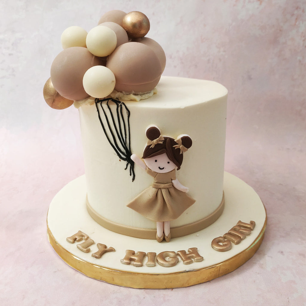 This girl and balloons cake features a canvas of pristine white, as pure and soft as the clouds that dance across the summer sky.