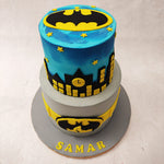 A grey bottom tier and a night sky blue top tier with the silhouettes of the buildings seen on it make up the majority of this Batman cake design.