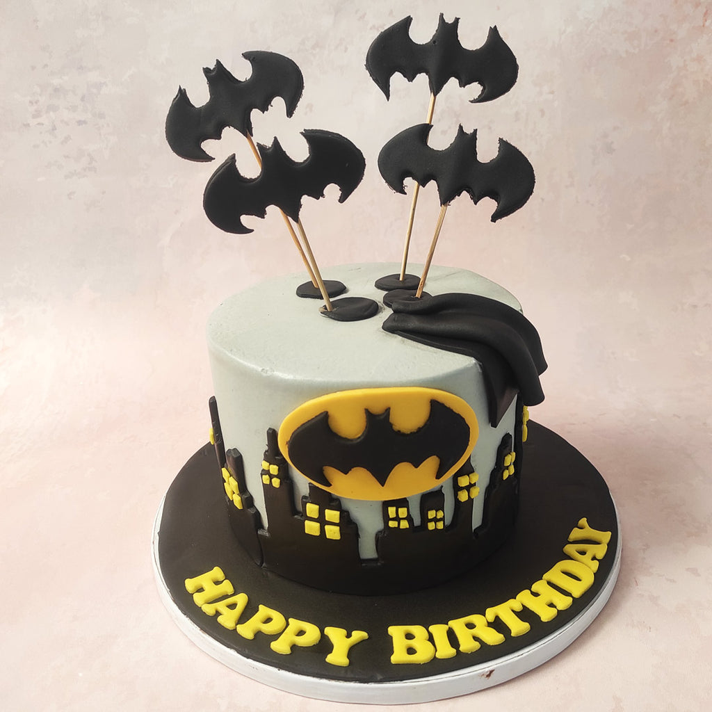 With a grey base reminiscent of Gotham's skyline and black buildings adorned with yellow windows, this Gotham City Cake features a silhouette of the city at night. 