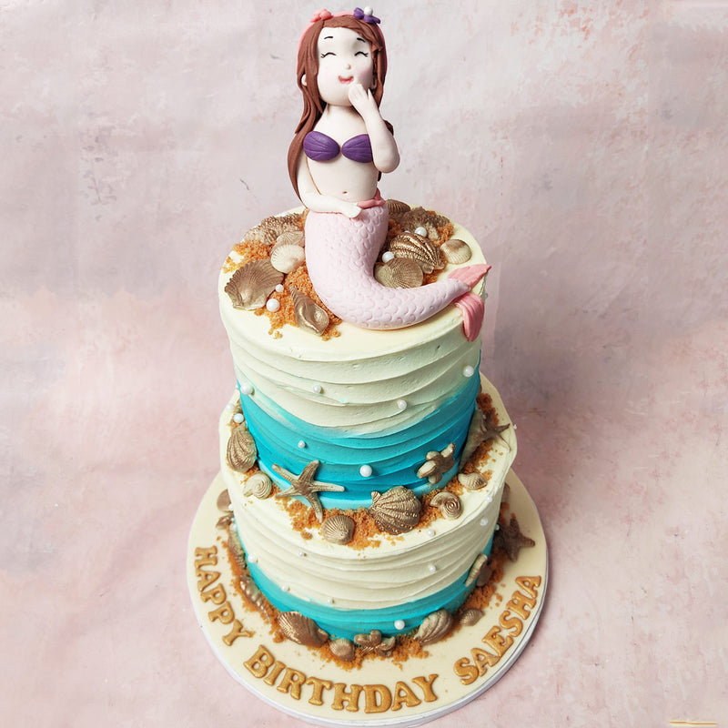 Golden clamshells, starfish, and an array of treasures adorn the underwater wonder that is this Mermaid Beach Cake 