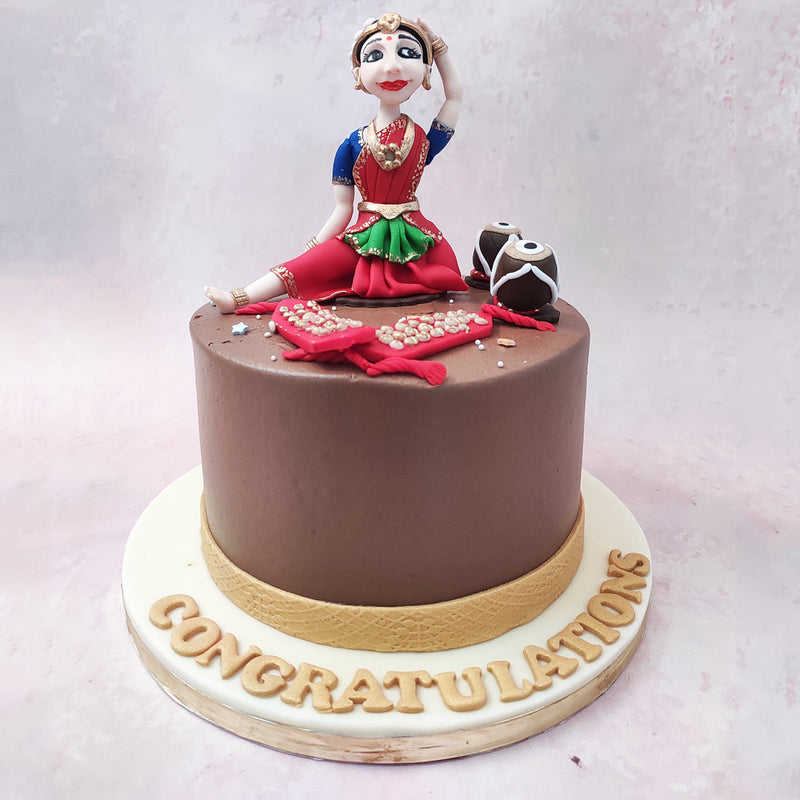 The cake for dancers design is elegantly designed with a brown base, representing the earthy tones of the dance form. 