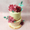 Meanwhile, the top tier is adorned with a luxurious gold ribbon, accentuated by scattered gold leaves, elevating this Two Tier Bouquet Cake's opulence.