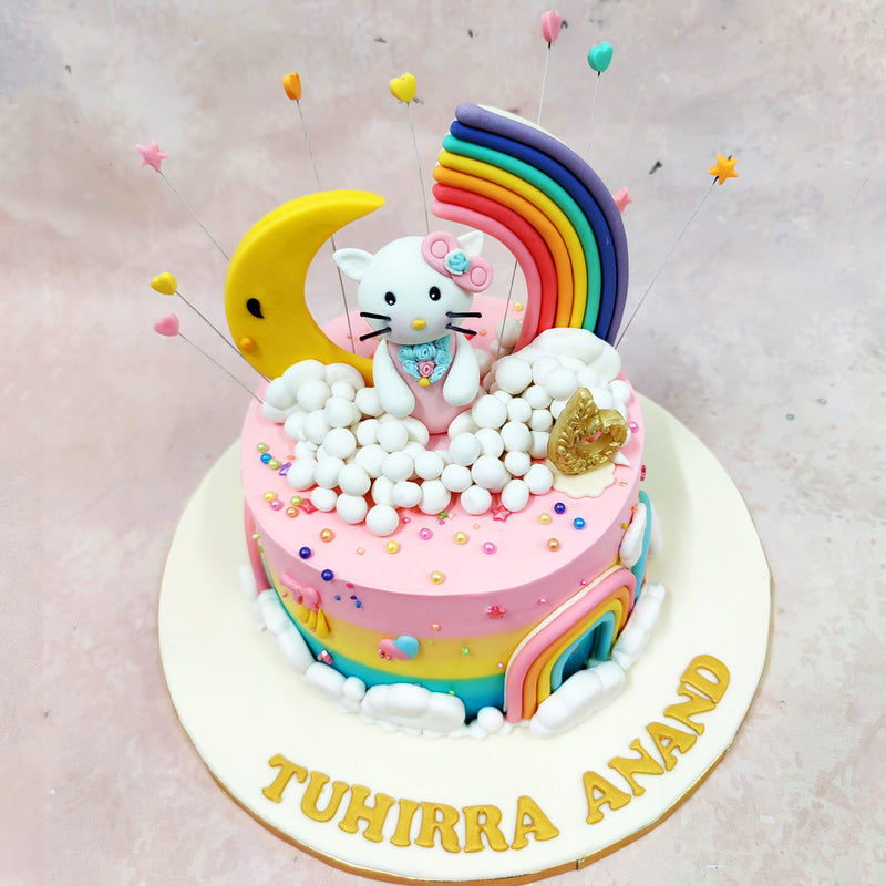 The base of this Birthday Cake For Girls blends pink frosting into a vivid rainbow gradient, complete with fondant rainbows on either side, tiny stars, bows, and clusters of cottony clouds wrapping around the bottom. 