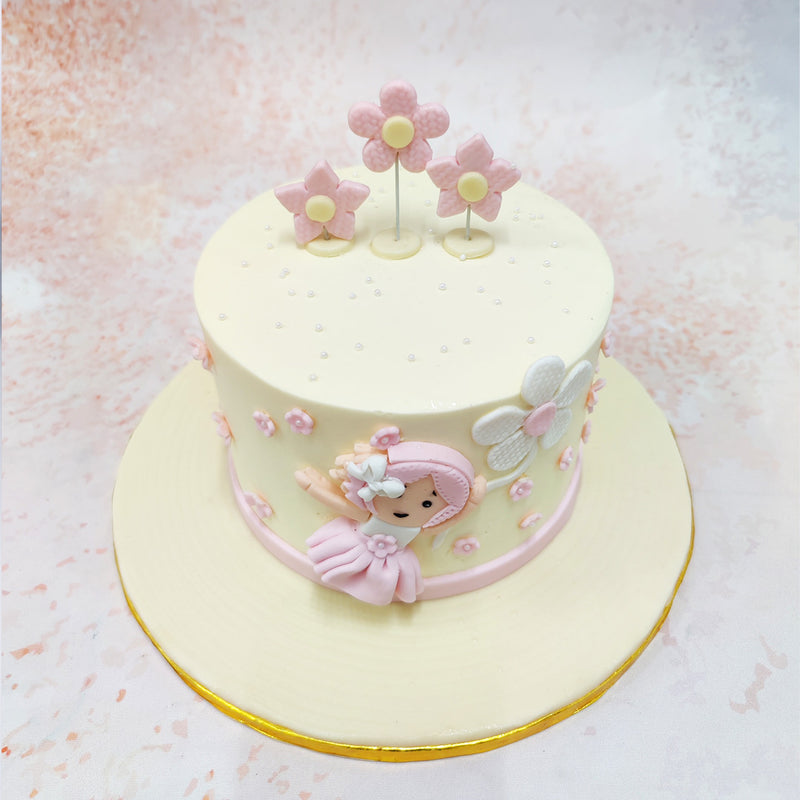 The soft pink flowers that dot the surface of this Girl With Flowers Cake add a touch of grace, symbolising purity and the blossoming of life’s sweetest moments.