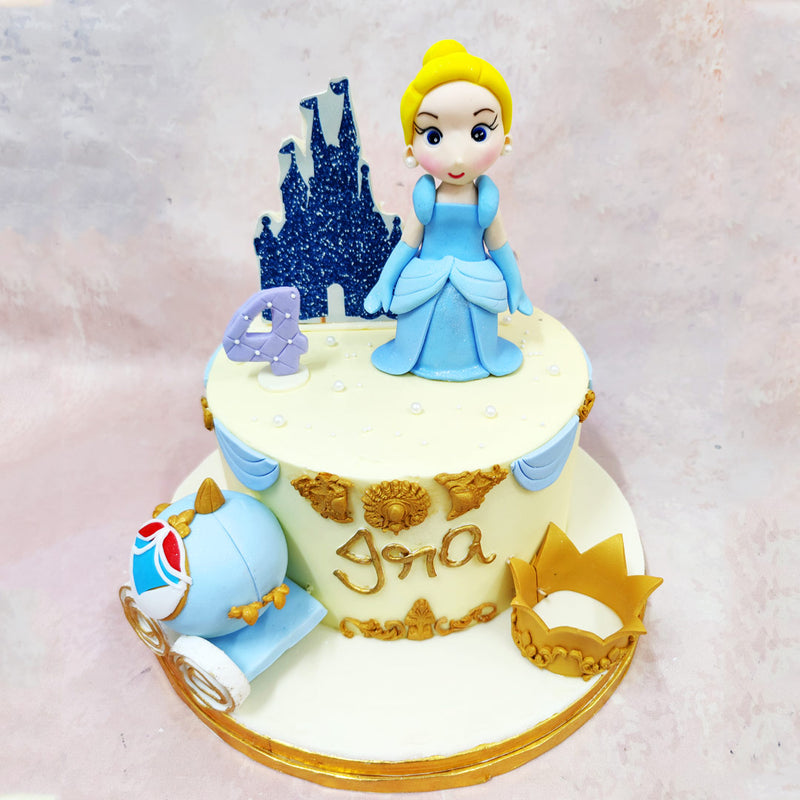 The handcrafted Cinderella figurine stands gracefully in the centre of this Birthday Cake For Girls, her powder-blue gown flowing with soft pleats that catch the light. Behind her, a sparkling midnight-blue castle silhouette sets the scene, adding depth and grandeur.
