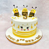 The front of this Birthday Cake For Kids features a sweet little face with blushing cheeks, fluttery lashes, and a tiny beak, turning the entire cake into a character of its own. Yellow stripes and piped floral accents wrap around the base, while teardrop-shaped honey drips fall gently from the top edge—adding texture and that sticky-sweet honeycomb vibe without overwhelming the design.