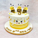 The front of this Birthday Cake For Kids features a sweet little face with blushing cheeks, fluttery lashes, and a tiny beak, turning the entire cake into a character of its own. Yellow stripes and piped floral accents wrap around the base, while teardrop-shaped honey drips fall gently from the top edge—adding texture and that sticky-sweet honeycomb vibe without overwhelming the design.