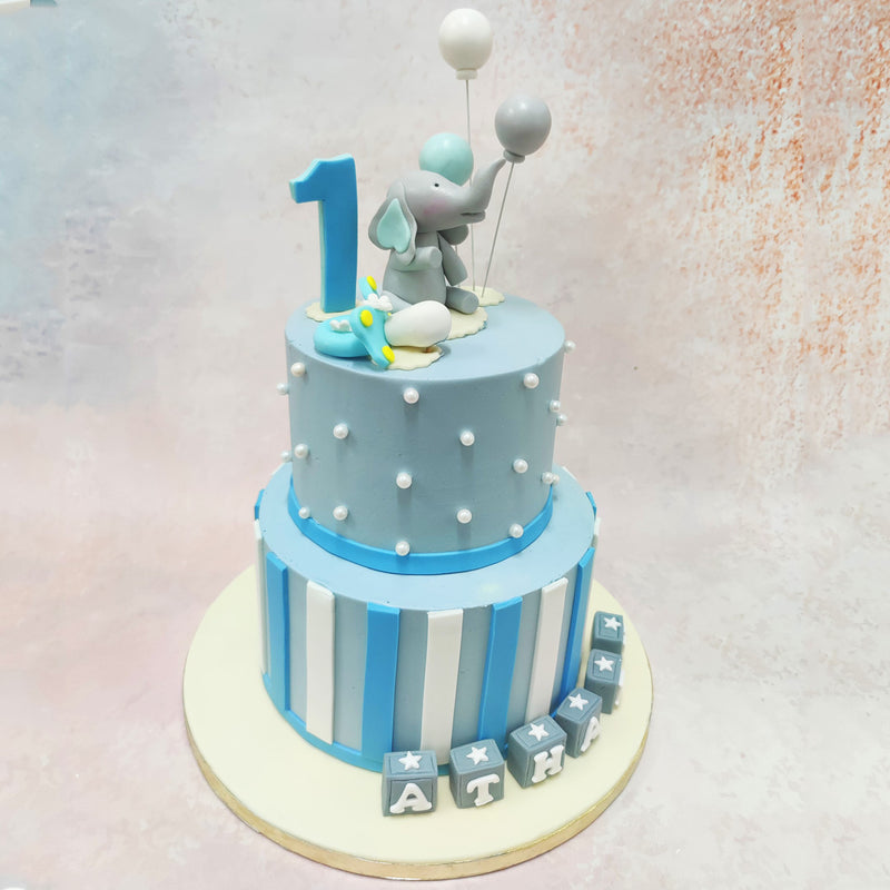 The pearl-studded celebration Birthday Cake For Kids adds elegance with its perfectly spaced sugar pearls adorning the top tier, while floating accent details create movement and energy throughout the design.