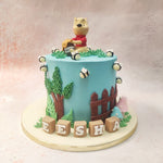 The backdrop of this Winnie The Pooh Theme Cake is a serene blue sky, accented by lush green grass and charming bees buzzing around, which captures the playful essence of the Hundred Acre Wood.