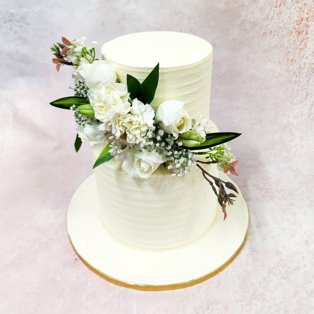 The botanical adornments symbolise purity and new beginnings, reflecting centuries-old wedding traditions where white flowers represented virtue and fidelity around the Birthday Cake For Wife’s graceful silhouette.