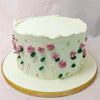 Adorning this enchanting green cake with handpainted roses are meticulously crafted pink buttercream roses. 