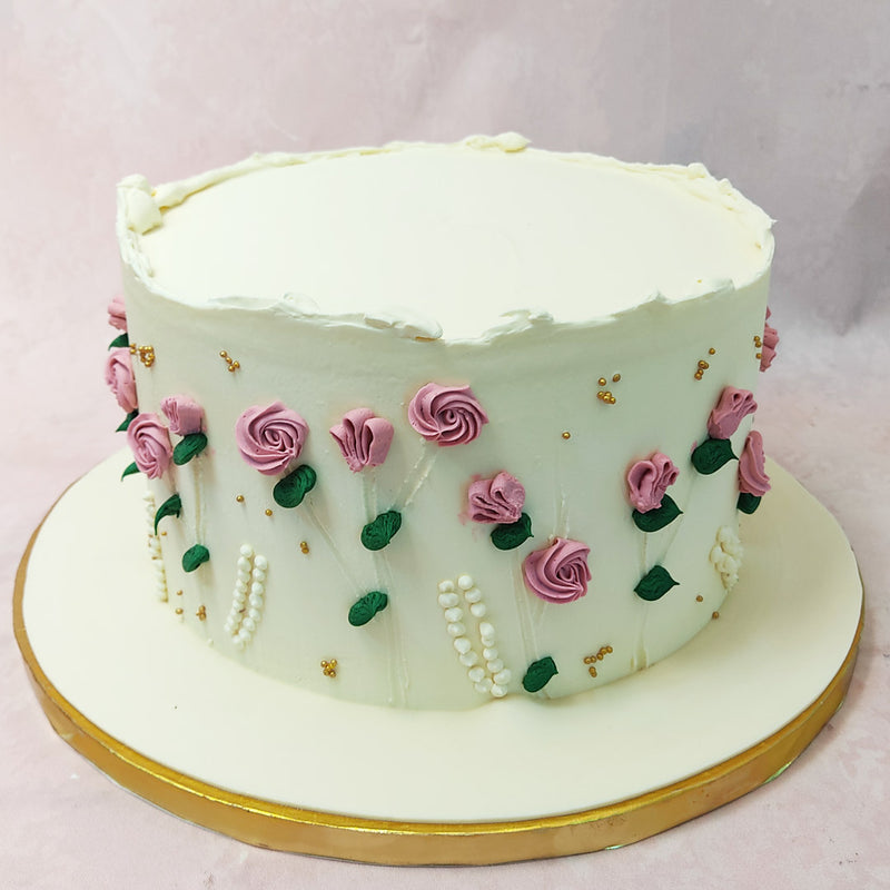 Adorning this enchanting green cake with handpainted roses are meticulously crafted pink buttercream roses. 