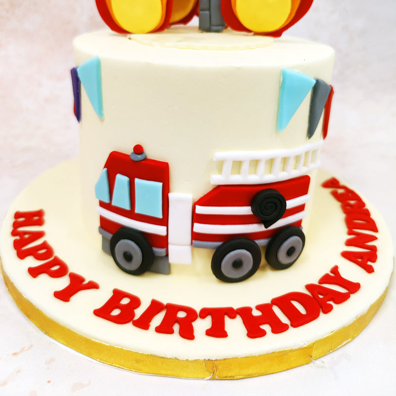 A cheerful bunting of alternating red and turquoise triangles circles this Birthday Cake For Kids, adding a festive touch while complementing the emergency services theme. 