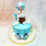 The design of this Birthday Cake For Kids showcases a dreamy sky-blue canvas decorated with cascading fluffy white clouds and a silver elements that create the illusion of gentle rain or twinkling stars.