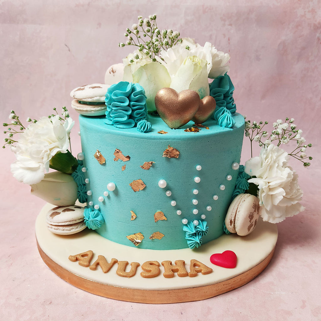 Fresh white flowers and delicate baby's breath adorn the light blue bases of this Blue Floral Cake.