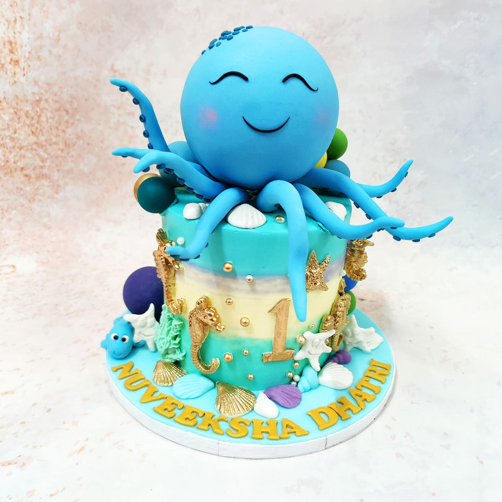 The star of this Blue Octopus Cake is an adorable blue octopus perched atop, sporting a heartwarming smile and rosy cheeks that exude pure joy. 