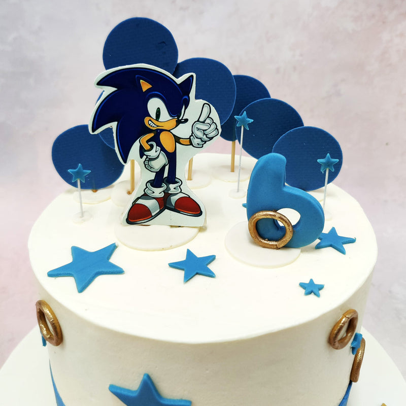 The focal point of this Blue Star Cake is a dynamic topper featuring Sonic in his signature pose, capturing his confidence and energy. 