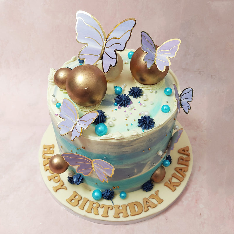 With a flawless blue and purple ombre smooth buttercream coating, this blue and purple butterfly cake design embodies elegance and sophistication. 