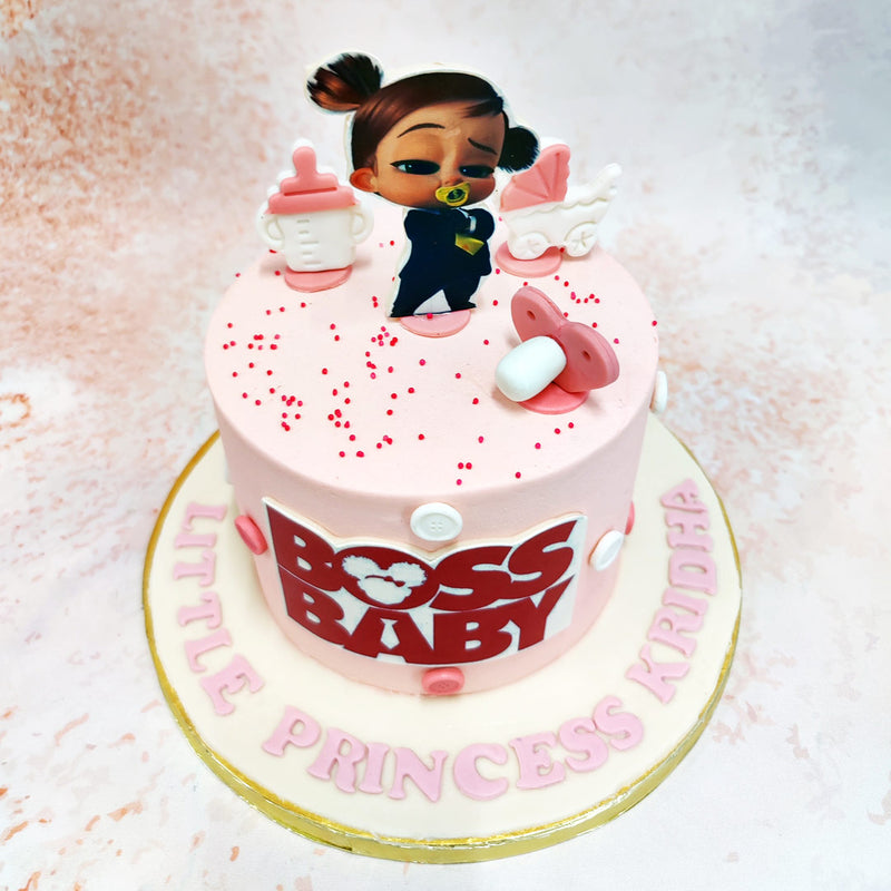 Standing confidently atop this Boss Baby Cake For Girls is the mini-version of Girl Boss Baby herself, complete with her signature pacifier and determined expression. 