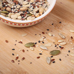 Bowl filled with various raw seeds for a trail mix, including pumpkin, sunflower, and chia seeds