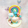  Perched atop this Butterfly Boy or Girl Cake is a miniature rainbow crafted in pastel hues—yellow, peach, pink, blue, and mint—representing the promise and hope that accompanies new beginnings.
