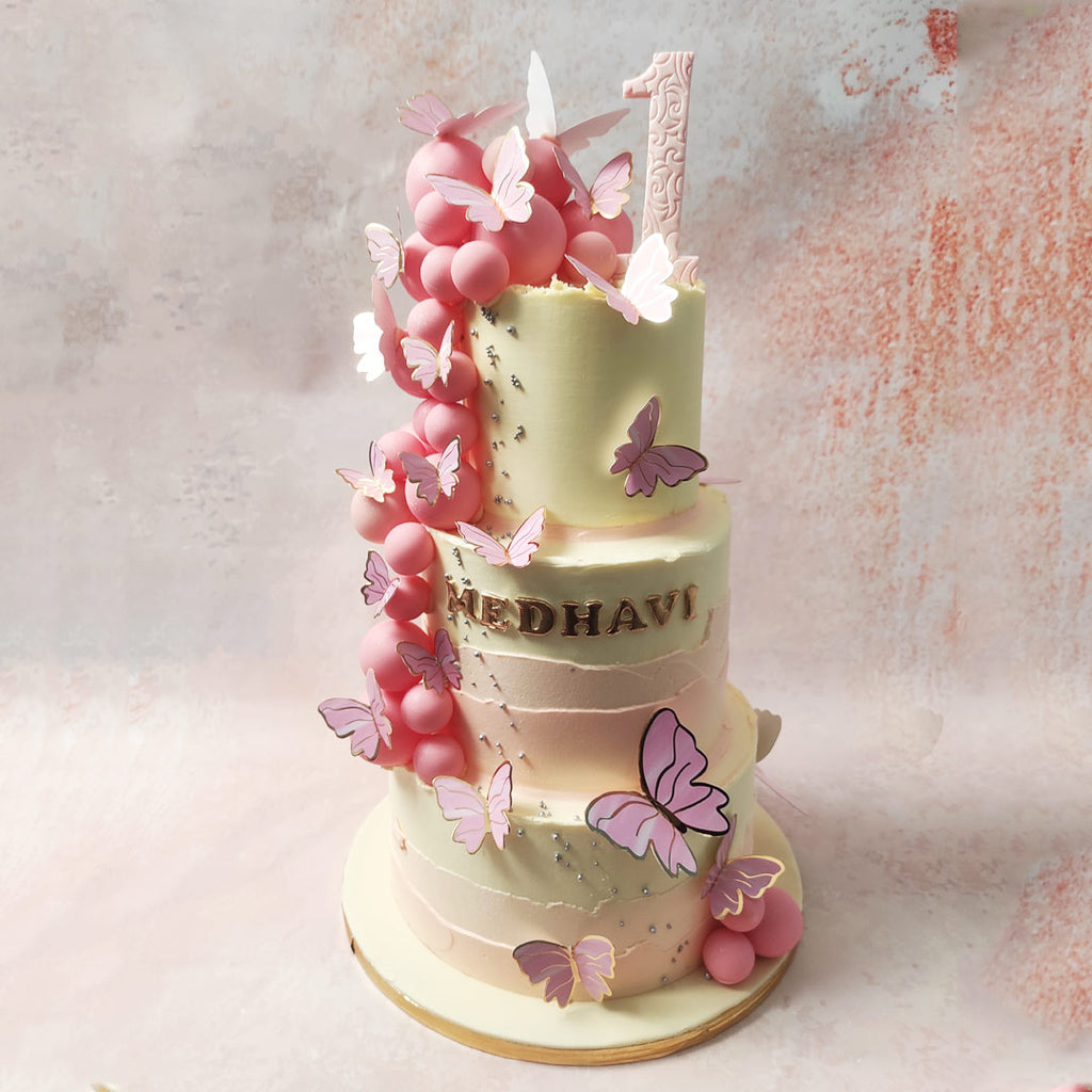 Spot beautiful butterflies on this 3 Tier Butterfly Cake, poised gracefully atop the spheres, their wings kissed by hues of purple and gold. 