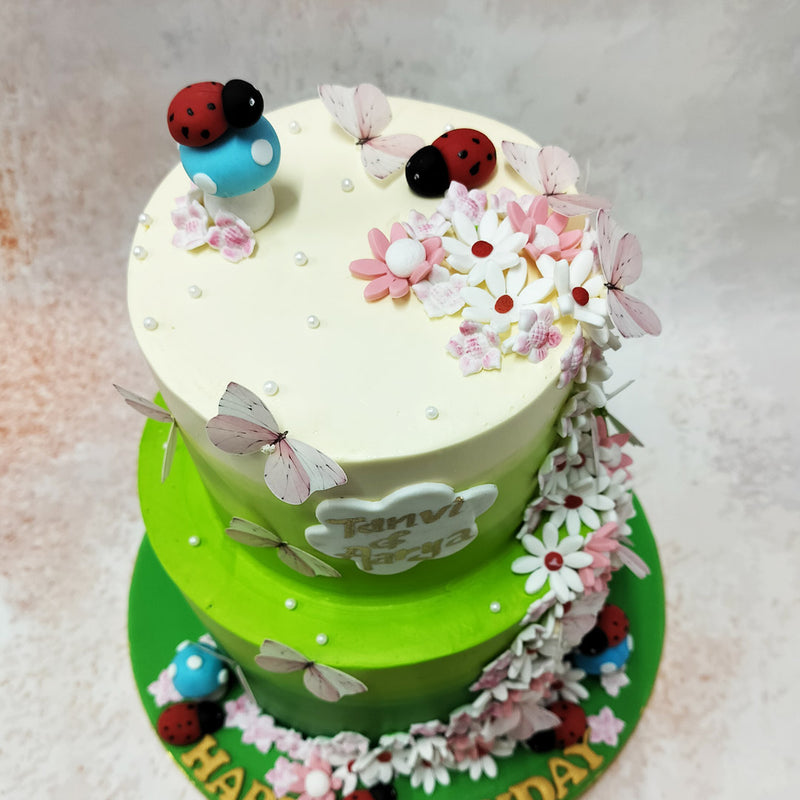 Adorning the cake are delightful accents of nature's own handiwork – delicate ladybugs, charming blue mushrooms, and graceful light pink 3D butterflies.