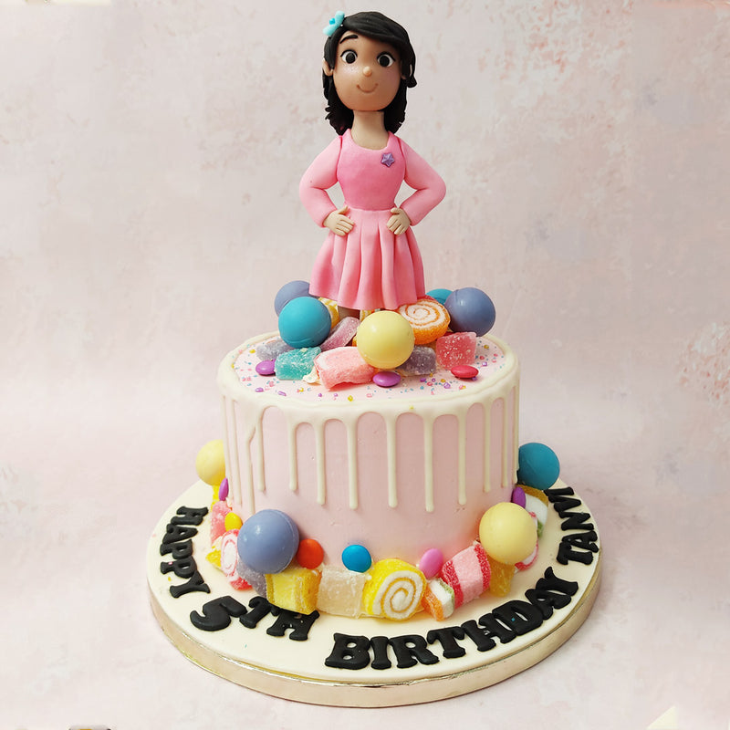 Featuring a pastel pink base, with decadent buttercream frosting aesthetically dripping down the sides, this candy theme birthday cake for girls is every little one's big dream.