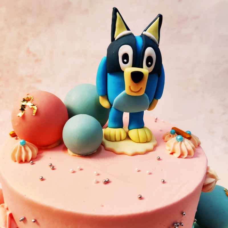 Bluey, standing proudly atop the Pink and Blue Bluey Cake, captures the essence of the adventurous and imaginative pup who has become a favourite in households everywhere. 