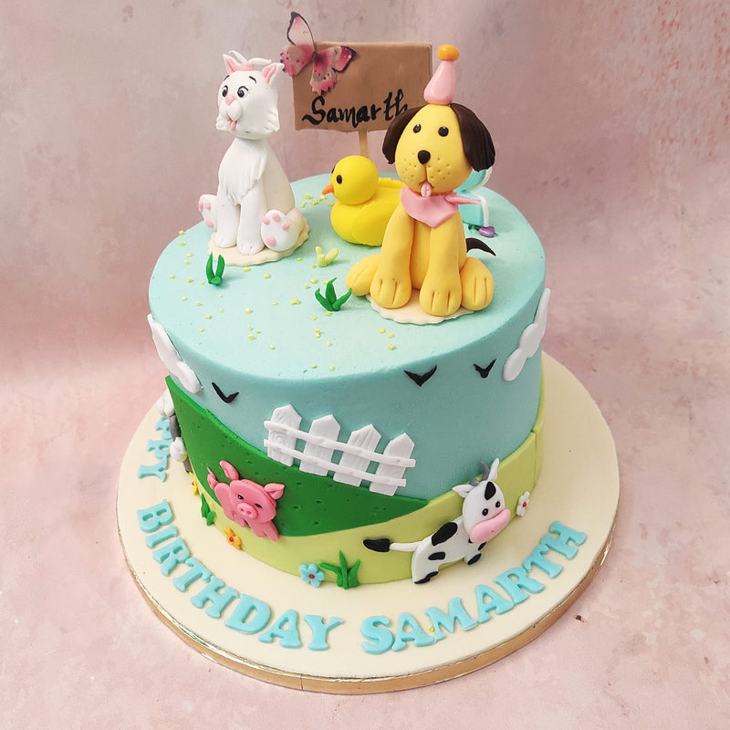 This Barnyard birthday cake for kids is beautifully decorated with rolling green hills and a white picket fence, symbolising the idyllic nature of farm life.
