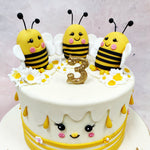 Sitting proudly on top of this Chibi Cake are three smiling bees with rosy cheeks, stripey tummies, and the friendliest expressions, nestled among daisies and golden sprinkles. 