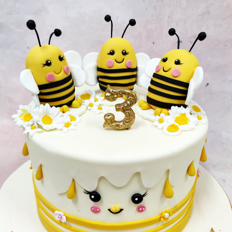 Sitting proudly on top of this Chibi Cake are three smiling bees with rosy cheeks, stripey tummies, and the friendliest expressions, nestled among daisies and golden sprinkles. 