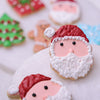 Close-up of a Santa face Christmas sugar cookie decorated with red hat and thick white beard icing