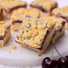 Close-up of a festive Christmas Cherry Crumb Cake square, showing the buttery base, rich cherry filling, and golden crumble topping.
