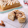 Christmas cinnamon roll pulled apart, showing the soft, fluffy interior, cinnamon swirl, and creamy white icing.