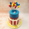 The top tier of this Circus Theme Cake features a bright blue base, adorned with playful details like tickets and golden stars, evoking the nostalgic feel of a big-top circus. 