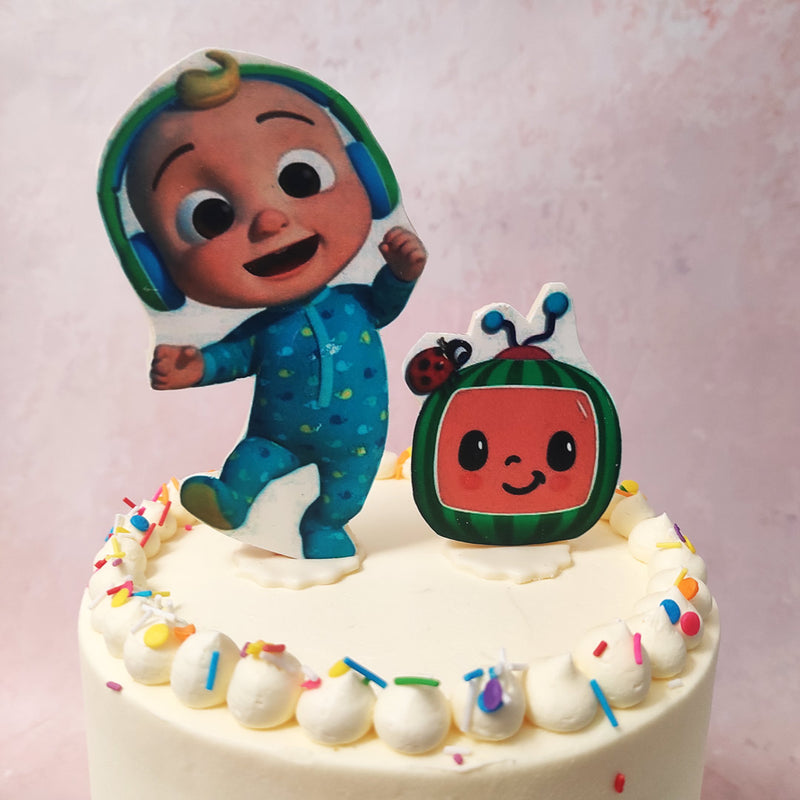 Next to the Cocomelon JJ cake topper are buttercream peaks, meticulously crafted to resemble the iconic logo of Cocomelon, featuring baby JJ and the adorable watermelon logo. 