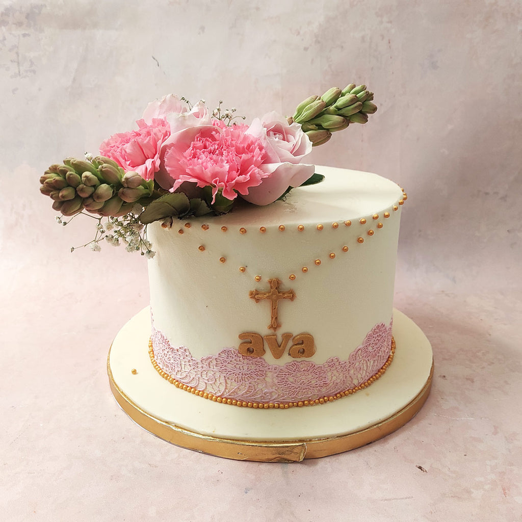On top of this Communion Cake With Flowers, a celestial rosary, crafted with the same gold pearls, leads to a central gold cross. 