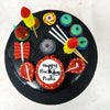 The sleek black backdrop of this Cracker Cake sets the stage for a bold and striking design, making the colourful decorations pop with energy. 