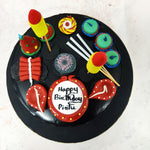 The sleek black backdrop of this Cracker Cake sets the stage for a bold and striking design, making the colourful decorations pop with energy. 
