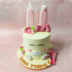 Moving upward, discover the bunny’s nose at the centre of this cute bunny cake, crafted in a charming light pink heart shape with blushing cheeks and pretty eyelashes that frame a closed-eyed warm smile.