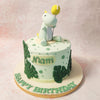 This Cute Dino Cake features a delightful dinosaur topper holding a yellow balloon, perched atop with an adorable expression that is sure to capture hearts. 