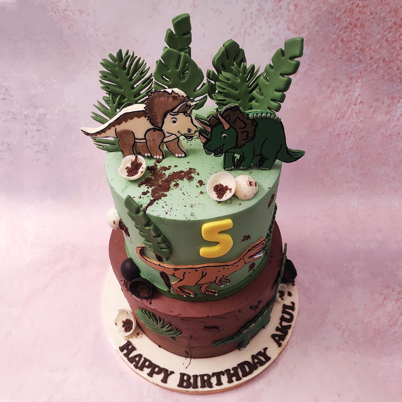 Cartoonish figurines of Dinosaurs and plant life embellish the entirety of this Dino theme cake, the graphics making it the perfect birthday cake for kids.