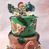 Ascending to the upper tier of this Baby Dinosaurs Cake, lush greenery flourishes, with intricately crafted palm leaves and the mystery of hatched dinosaur eggs adding to the allure.